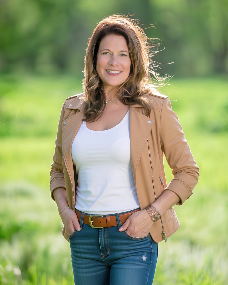Tiffany Edgar standing in a green field, smiling